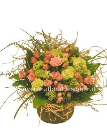 Cestino di vimini o ceramica, rose e verde pregiato.